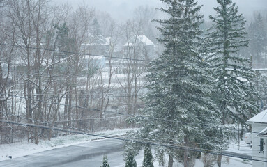 Looking down on a snow covered road within Torrington Connecticut during a winter storm as snow coats everything.