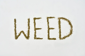'Weed' word from dry marijuana on white background