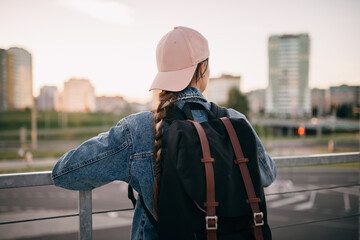 Tourist admires the overview of the sights of the city. Woman with backpack enjoy beautiful city view, traveler mock up top of the city. - 517356189