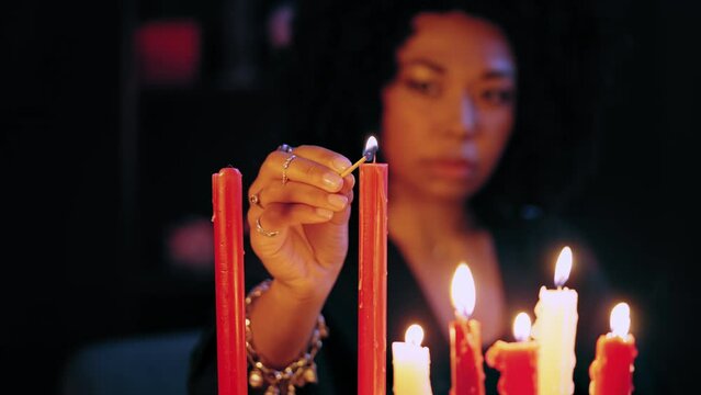 Woman lighting candles before magic ritual, fortune-telling, psychic powers