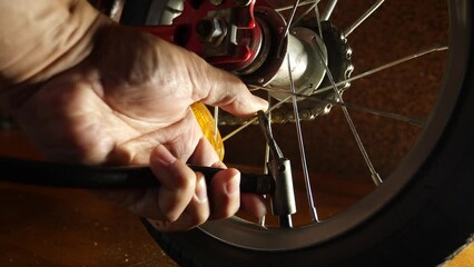 The bicycle wheel is inflated with a hand pump. Service and maintenance of bicycles.