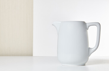 Milk jug on wooden background. Porcelain sauce boat, pitcher, creamer or ceramic gravy boat