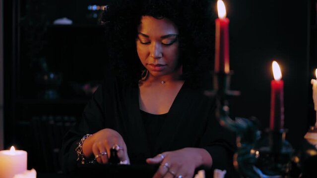 Black witch holding voodoo doll, preparing for occult ritual, dark magic power