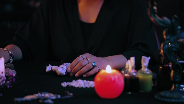 Evil witch piercing voodoo doll with pins, performing black magic ritual, curse