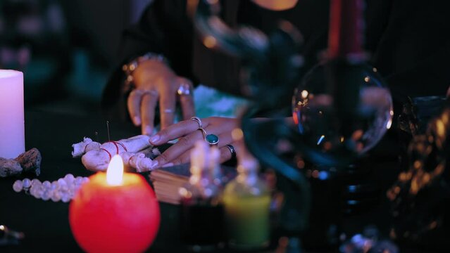 Black witch performing evil ritual, piercing voodoo doll with pins, dark magic