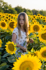 Little girl on the field with sunflowers blurred background