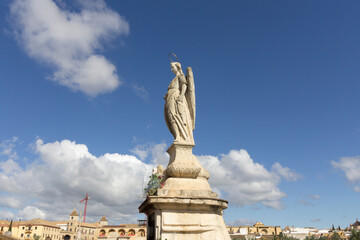 Fototapeta na wymiar Statue of Saint Raphael in the middle of the Roman Bridge, Puente Romano in Cordoba, Spain.