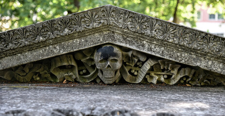 Photography of architectural detail on old building. Replica of human skull with decorative detail.