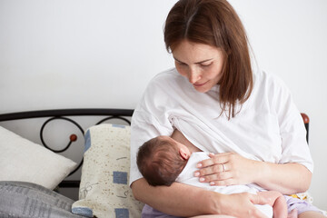 Mother breastfeeding her newborn baby boy. Realistic home portrait - obrazy, fototapety, plakaty