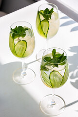 Three cocktails with ice, cucumbers and mint