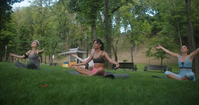 Young athletes raise arms doing yoga breathing practices
