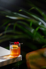 A cocktail with ice, orange peel and cherries