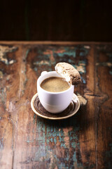 Cantuccini (Italian cookie) and a Cup of coffee on dark wooden background. Copy space	