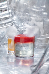 Cocktail with ice, red and yellow juice