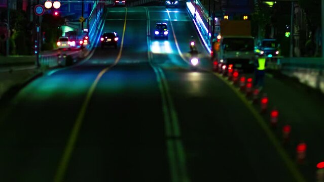 A night timelapse of the miniature traffic jam at the urban street in Tokyo panning