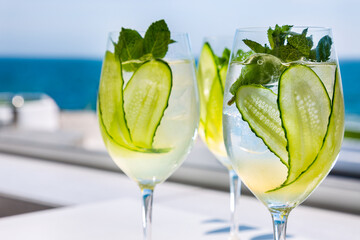 Three cocktails with ice, cucumbers and mint