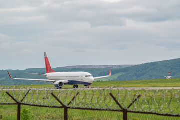 a civilian passenger plane with turbojet engines accelerates along the runway on the airport field...