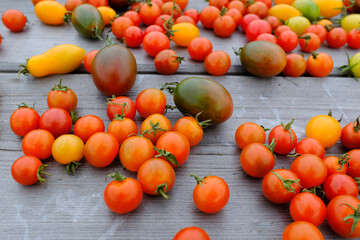 Ripe tomatoes are scattered on the wooden background, upper view. Fresh tomatoes for publication, poster, screensaver, wallpaper, postcard, banner, cover, post. High quality photography