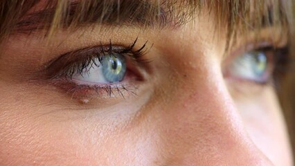 Woman opening blue eyes and blinking, thinking serious thoughts. Close up female with intense stare, in a state of wonder and dreaming of ideas. Lady looking awake and aware