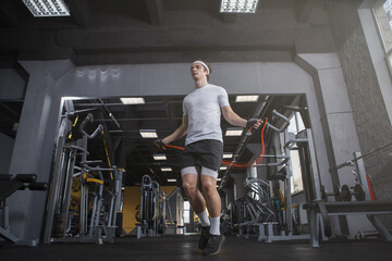 Low angle shot of a sportsman skipping on jumping rope at gym