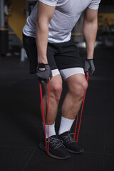 Vertical cropped shot of a sportsman doing resistance band workout