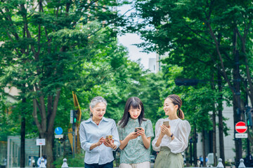 スマートフォンを使うさまざまな世代の女性