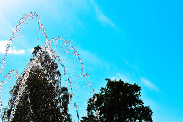 close-up water jet fountain against blue sky