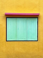 Obraz na płótnie Canvas Retro wooden window on yellow wall