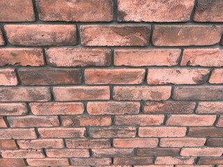 オレンジ色と茶系のレンガ壁の背景テクスチャ