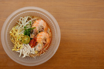 A picture bowl of Laksa Sarawak on copyspace table. In consist of vermicelli, prawns, coconut soup...
