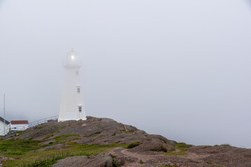 Fototapeta na wymiar The lighthouse at Cape Spear, Newfoundland, the easternmost point in North America, is seen drenched in a thick layer of fog.