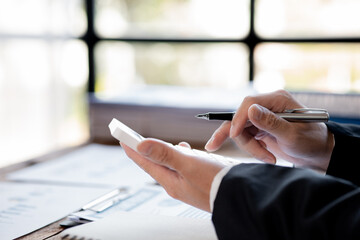 A female financier is reviewing company financial documents, monthly financial statement summary from the finance department. The concept of managing the company's finances for accuracy and growth.