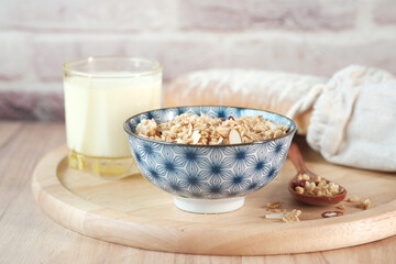 Home Made Musli in a bowl, glass of milk and bread on table 