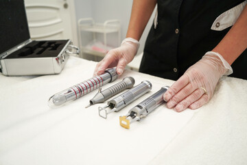 A doctor gynecologist preparing instruments and laser for antiaging procedures of women patients