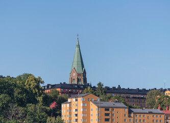 Fototapeta na wymiar Church and apartment buildings in the district Södermalm a sunny summer day in Stockholm