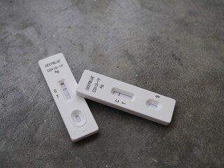 Close-up photo of ATK test kit for Covid-19 testing positive and negative results placed on gray cement background suitable for illustration Bangkok Thailand, 15th July 2022