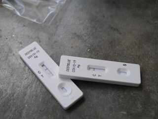 Close-up photo of ATK test kit for Covid-19 testing positive and negative results placed on gray cement background suitable for illustration Bangkok Thailand, 15th July 2022