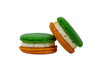 Delicious French Macarons: Two colorful macarons, pistachio and tangerine hued, stacked high on a simple surface, offering a sweet treat.