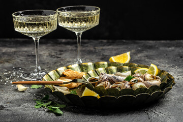Fried snails Escargots de Bourgogne with herbs, butter, garlic on metal plate with forks, wine glass. gourmet food. Restaurant menu, dieting, cookbook recipe