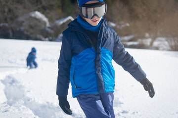 Boy hiking on a track knee deep in snow