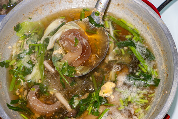 Preparing traditional Suki soup by cooking in a pot