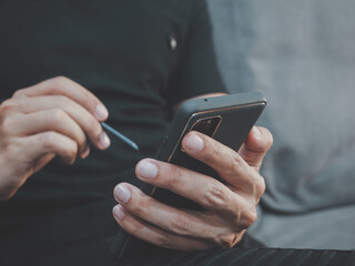 man using smartphone device while sitting on sofa at home. work business, social network.Concept of young people working mobile devices.