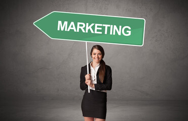 Young business person in casual holding road sign