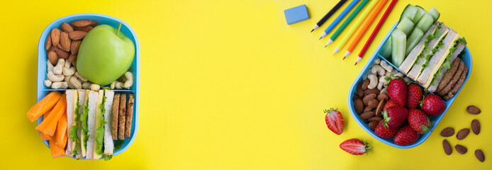Banner. School lunch in the blue box and school stationery on the yellow background. Top view. Copy...