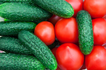 lots of cucumbers and tomatoes. Fresh vegetables on the table. Healthy food concept. Gherkins and red tomatoes.
