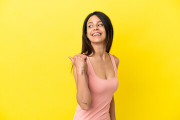 Young caucasian woman isolated on yellow background pointing to the side to present a product