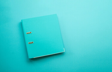 Hardcover business folder for portfolio and documentation lying on blue background. Paper organizer...