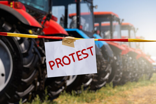 The inscription PROTEST on the background of tractors. Farmers protest symbol.