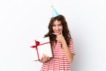 Young woman with curly hair holding present isolated on white background happy and smiling