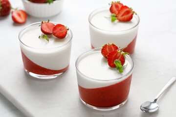 Panna cotta with strawberry in a glass jars decorated with fresh berries and mint, Traditional Italian sweet dessert. Strawberry creamy dessert - panna cotta.